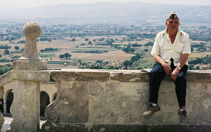 An old-timer rests on a ledge in Assisi